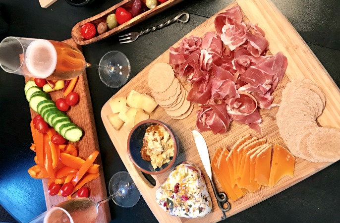 Homemade charcuterie and cheese board with a side of bubbles.